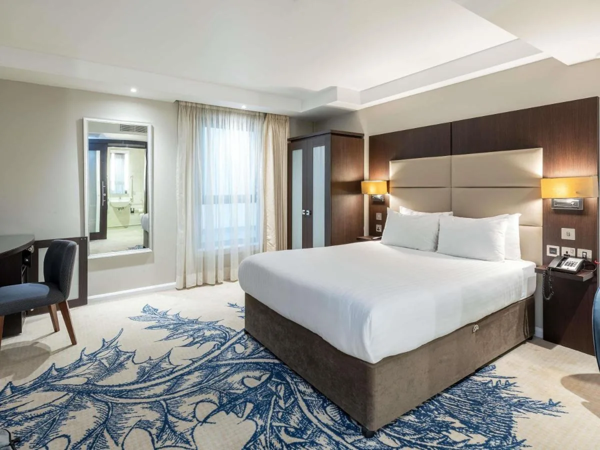 a hotel room with a bed and a desk at Mercure Edinburgh Haymarket in Edinburgh